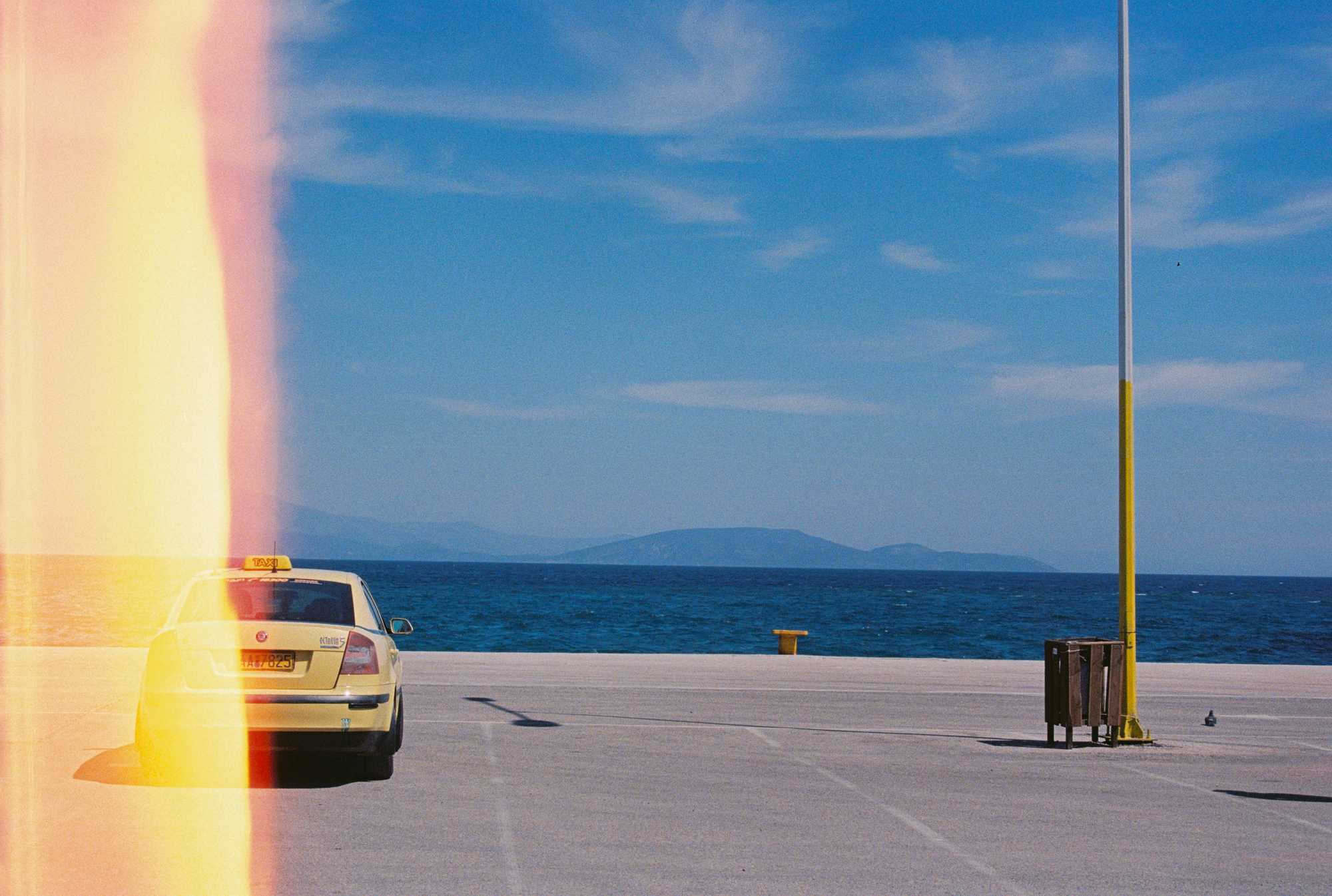 Car on harbour wall with view of the mediteranean see in Greece