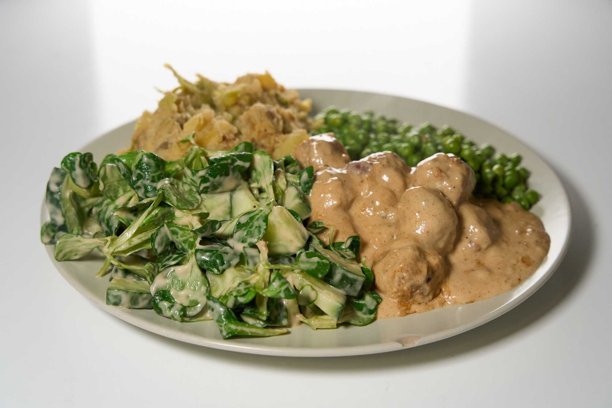 Köttbullar in Sose mit Erbsen, Salat und Kartoffelbrei