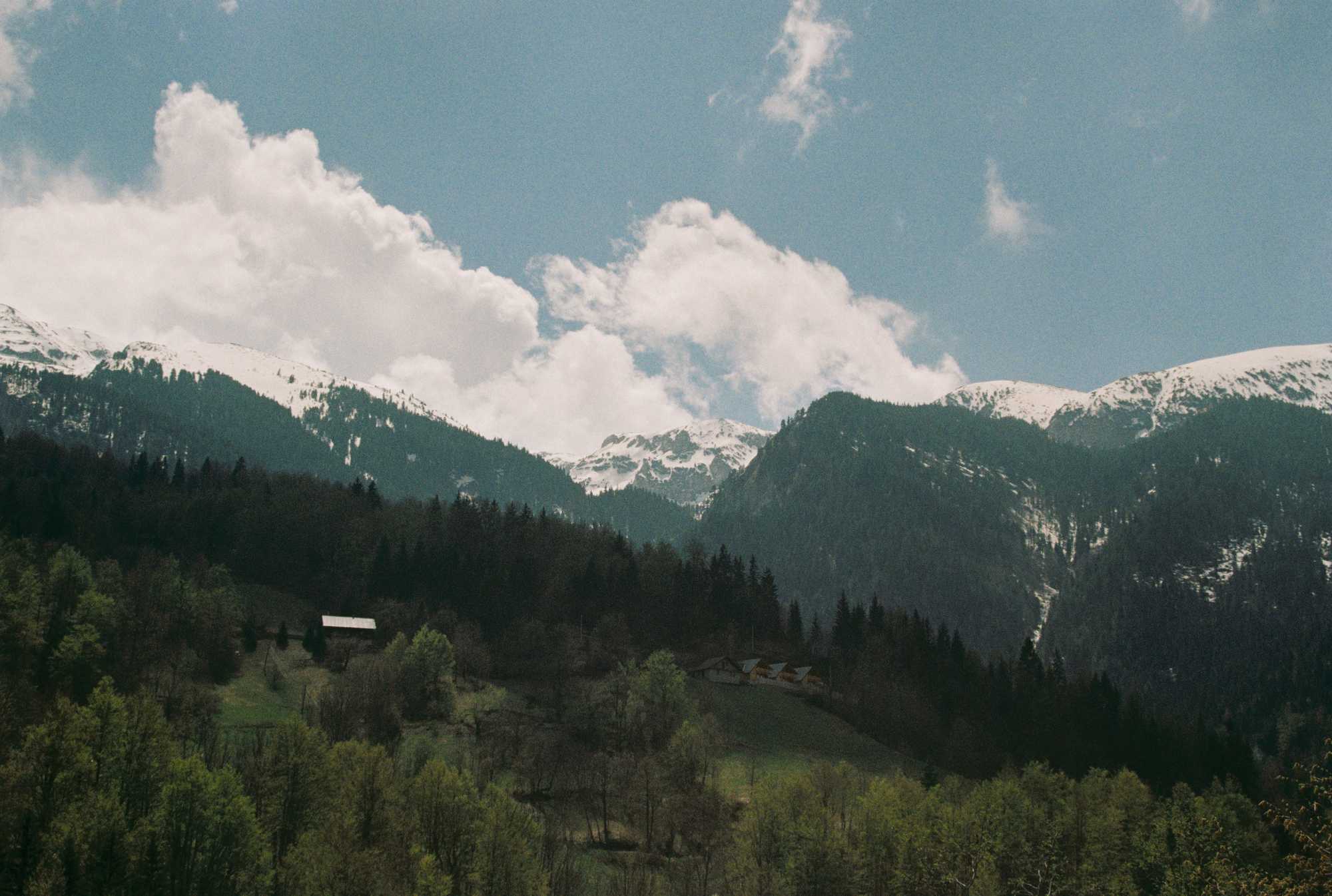 House in front of mountains, again, but there is also forest