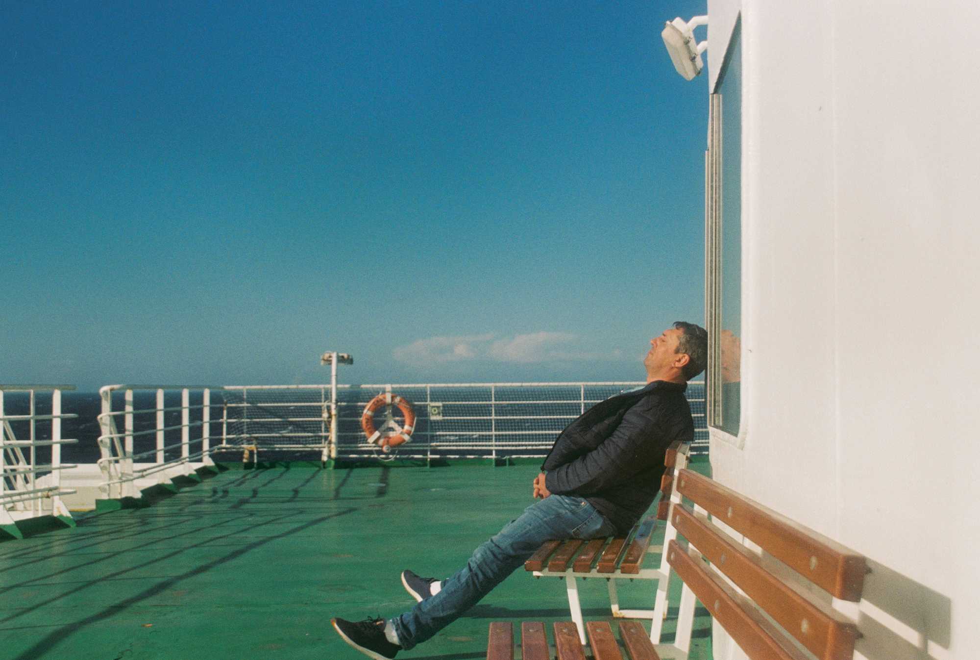 A person realxing in the sun on a ferry